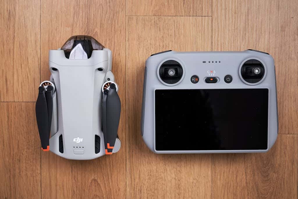 Top view of a DJI Mini 3 Pro drone and controller set on a wooden floor, showcasing modern drone technology.