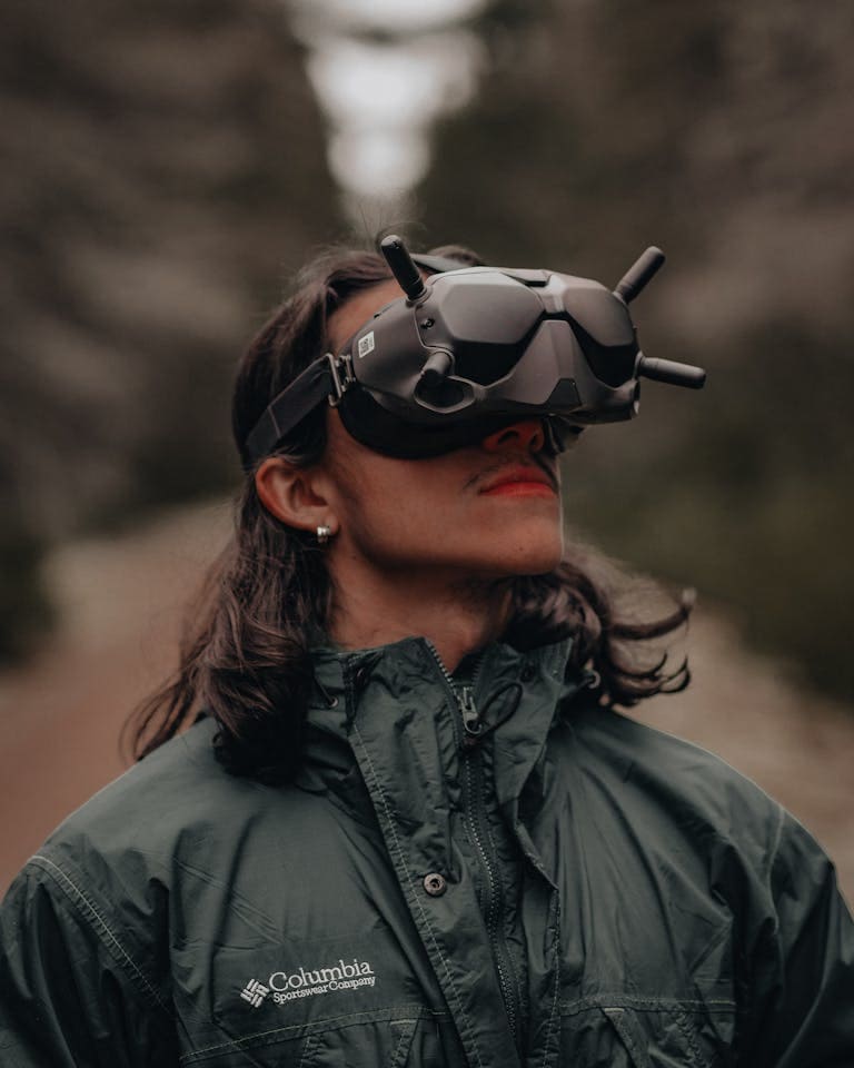 A person wearing FPV goggles enjoys the forest outdoors, showcasing adventure and technology.